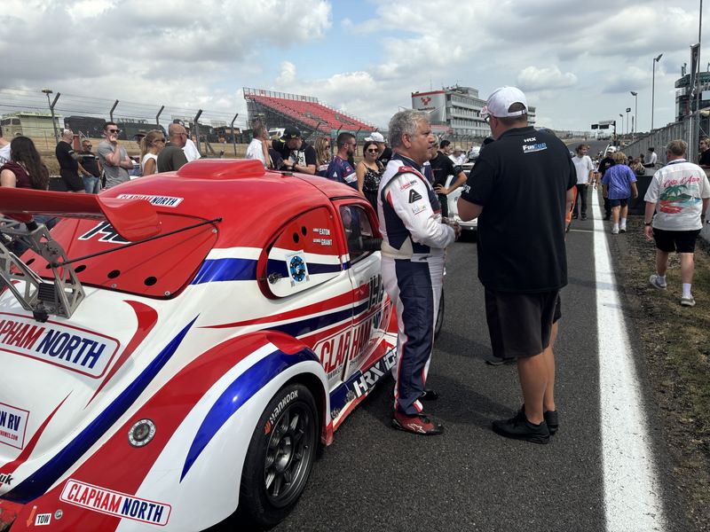 George Grant in his race suit beside Car 146 on the grid