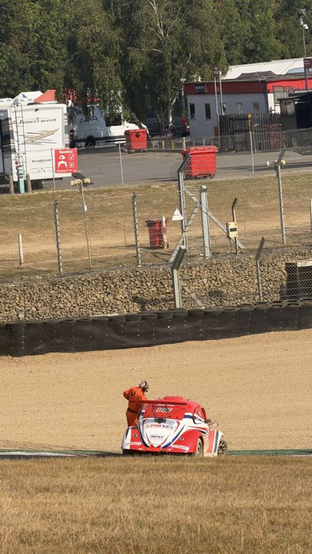 A red Fun Cup car stopped in the gravel trap