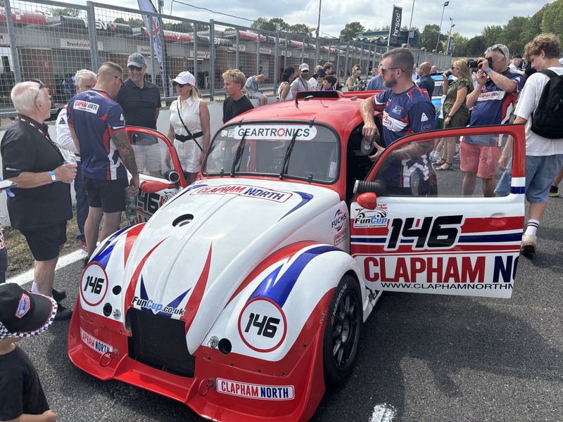 Car 146 with its doors open on the grid, team and guests around it
