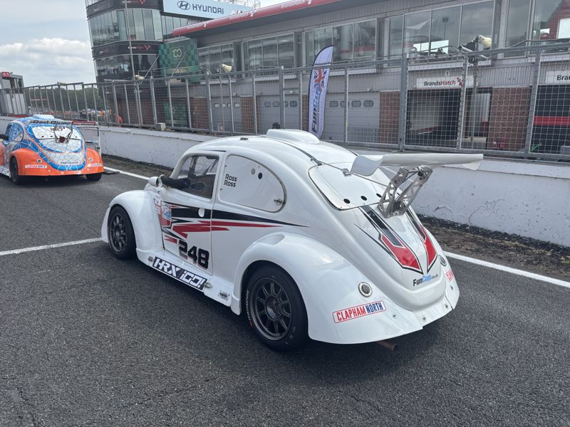 A white Fun Cup car arriving on the grid in front of the pits